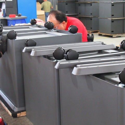 Individuals assembling metal enclosures
