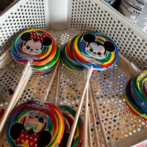 suckers sitting in a perforated metal basket on a point of purchase display