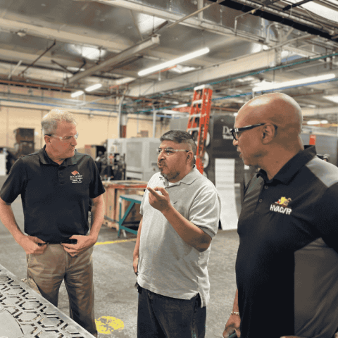 three men in a sheet metal fab shop